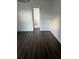 Bright bedroom featuring a view of bathroom and rich dark wood-look laminate flooring at 2900 S Semoran Blvd # 1, Orlando, FL 32822