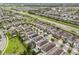 Aerial view showcasing a community with well-maintained lawns, pools, and solar panels, near a highway at 331 Pendant Ct, Kissimmee, FL 34747