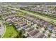 Aerial view showcasing a community with well-maintained lawns, pools, and solar panels, near a highway at 331 Pendant Ct, Kissimmee, FL 34747