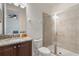Bright bathroom featuring a glass shower and a vanity with a granite countertop and dark wood cabinets at 331 Pendant Ct, Kissimmee, FL 34747