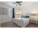 This bedroom features a ceiling fan, carpet, a window with curtains, and white nightstands at 331 Pendant Ct, Kissimmee, FL 34747