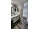 Bright bathroom features a white vanity, two mirrors, and a walk-in shower at 4341 Aqua Vista Dr # A, Orlando, FL 32839