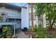 Two-story condo building with gray paint, a small balcony, and trees surrounding the front at 4341 Aqua Vista Dr # A, Orlando, FL 32839