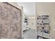 A well-lit bathroom features modern fixtures, a shower with patterned curtains, and storage shelves at 4410 Mildred Bass Rd, St Cloud, FL 34772