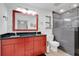 Bright bathroom featuring a red vanity with dual sinks and a tiled walk-in shower with bench seating at 4410 Mildred Bass Rd, St Cloud, FL 34772