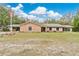 Inviting single-story home features an American flag, a manicured front lawn, and a brick facade accented with tan trim at 4410 Mildred Bass Rd, St Cloud, FL 34772