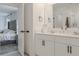 Clean white bathroom with double vanity sinks, black hardware, and modern finishes at 466 Cool Summer Ln, Davenport, FL 33837