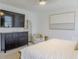 Bright bedroom with modern furniture, large-screen television, and decorative mirror at 466 Cool Summer Ln, Davenport, FL 33837