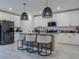 Modern kitchen features white cabinets, pendant lighting, stainless steel appliances, and center island with bar seating at 466 Cool Summer Ln, Davenport, FL 33837