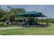 Community playground shaded by canopy, nestled on lush green grass, and equipped with modern play structures for outdoor fun at 466 Cool Summer Ln, Davenport, FL 33837