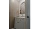 Elegant half bath with a decorative mirror, stylish vanity, and panelled wall at 466 Cool Summer Ln, Davenport, FL 33837