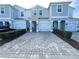 Charming townhome showcasing a paver driveway and manicured landscaping at 4736 Tribute Trl, Kissimmee, FL 34746