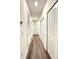 The long hallway has hardwood floors, white walls, and white doors to provide a simple design at 4736 Tribute Trl, Kissimmee, FL 34746