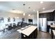 Open concept living and dining area featuring modern lighting and stainless steel appliances at 4736 Tribute Trl, Kissimmee, FL 34746