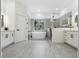Bright bathroom with a free standing tub, sleek glass shower, dual vanities, and a large window overlooking lush greenery at 5254 Mill Stream Dr, St Cloud, FL 34771