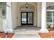 Elegant entryway with double doors, column supports, herringbone brick flooring, and pendant lighting at 5254 Mill Stream Dr, St Cloud, FL 34771