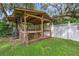Wooden gazebo features a wood-burning stove, bar seating, and ample space for outdoor entertaining at 5254 Mill Stream Dr, St Cloud, FL 34771