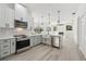 Open kitchen with stainless steel appliances, light gray cabinets, white countertops, and hardwood style flooring at 5254 Mill Stream Dr, St Cloud, FL 34771