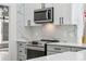 Modern kitchen features white quartz countertops, gray cabinets, stainless steel appliances, and stylish backsplash at 5254 Mill Stream Dr, St Cloud, FL 34771
