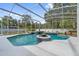 Enjoy this screened-in pool area featuring a blue tiled spa and lush landscaping for privacy at 5254 Mill Stream Dr, St Cloud, FL 34771