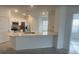Modern kitchen features white cabinetry, stainless steel appliances, and a large island with a countertop at 553 Se Turtle, Haines City, FL 33844