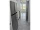 Modern kitchen with stainless steel refrigerator, countertops, and appliances, seamlessly connected to adjacent rooms at 553 Sea Turtle Ln, Haines City, FL 33844