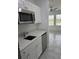 Well-equipped kitchen with stainless steel appliances, white cabinets, and stylish countertops with an adjacent living area at 553 Sea Turtle Ln, Haines City, FL 33844