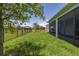 Expansive backyard featuring lush green grass, screened porch, and black aluminum fence at 5648 Cedar Chase Dr, St Cloud, FL 34771