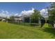 Large backyard with lush green grass, screened in porch, and black aluminum fence at 5648 Cedar Chase Dr, St Cloud, FL 34771
