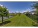 Beautiful view of the pond from the lush green backyard with a black aluminum fence at 5648 Cedar Chase Dr, St Cloud, FL 34771