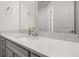 Bathroom with an elongated mirror over a white quartz countertop and gray vanity at 5648 Cedar Chase Dr, St Cloud, FL 34771