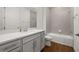 Well-lit bathroom with wood-look tile flooring, gray subway tile, and a white quartz countertop at 5648 Cedar Chase Dr, St Cloud, FL 34771