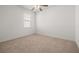 Bedroom features neutral carpeting, a ceiling fan, and a window with blinds at 5648 Cedar Chase Dr, St Cloud, FL 34771