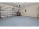 Spacious garage with epoxy flooring and an automatic garage door, plus a pair of garbage bins at 5648 Cedar Chase Dr, St Cloud, FL 34771