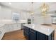 Kitchen island with white countertops, navy cabinets, pendant lights and stainless appliances at 5648 Cedar Chase Dr, St Cloud, FL 34771