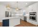 Stylish kitchen featuring white cabinets, stainless steel appliances, and a unique island at 5648 Cedar Chase Dr, St Cloud, FL 34771