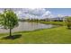 Beautiful view of the pond with lush green grass in the backyard of the home at 5648 Cedar Chase Dr, St Cloud, FL 34771
