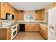 Well-lit kitchen featuring wood cabinetry, tile flooring, and modern appliances at 612 Lakeshore Blvd, Kissimmee, FL 34744