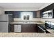 Modern kitchen features stainless appliances, dark cabinets, granite counters, and natural lighting at 626 Orange Dr # 243, Altamonte Springs, FL 32701