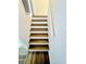 Interior staircase featuring wood stairs with white risers and a handrail at 658 Caribbean Dr, Davenport, FL 33897