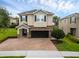 Exterior elevation of home featuring brick driveway, 2 car garage and manicured lawn at 7541 Marker Ave, Kissimmee, FL 34747