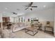 Open-concept living room with tile flooring, ceiling fans, and seamless flow to the kitchen and patio at 7541 Marker Ave, Kissimmee, FL 34747