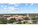 Aerial view features beautiful resort with red-tiled roofs, lush green landscaping, and a scenic lake backdrop at 759 Largo Pass, Poinciana, FL 34759