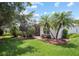 Landscaped backyard with lush grass, mature trees, and a screened patio at 759 Largo Pass, Poinciana, FL 34759