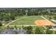 Overhead view of a well-maintained baseball field with lush green grass, parking, and surrounding trees at 759 Largo Pass, Poinciana, FL 34759