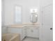 Bathroom with a white cabinet vanity, gold fixtures, shutters, and a soaking tub at 759 Largo Pass, Poinciana, FL 34759