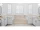 Bright bathroom features a soaking tub between vanities with white cabinets and drawers at 759 Largo Pass, Poinciana, FL 34759