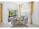 Bright dining area features a modern glass table and a sliding glass door to the patio at 759 Largo Pass, Poinciana, FL 34759