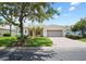 Charming single-story home featuring a well-manicured lawn, mature trees, and a paved driveway leading to a two-car garage at 759 Largo Pass, Poinciana, FL 34759