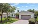 Inviting single-story home with a brick driveway, lush landscaping, and an attached two-car garage at 759 Largo Pass, Poinciana, FL 34759
